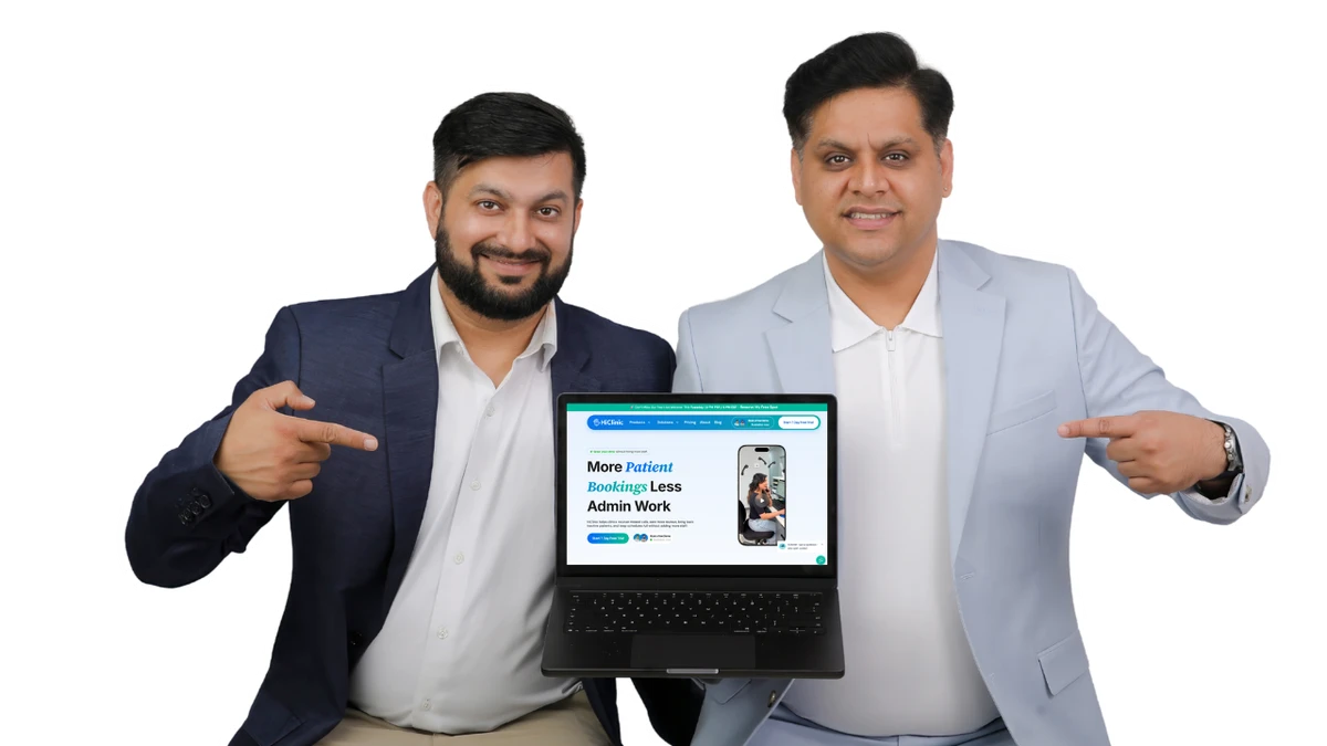 Dr. Varun Bajaj and Danish Wadhwa, co-founders of HiClinic, holding a laptop showing the HiClinic website